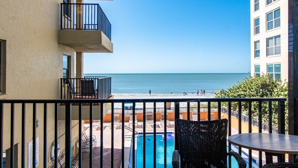 Un balcon avec vue sur la plage et la piscine.