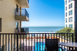 Un balcón con vistas a la playa y la zona de la piscina.