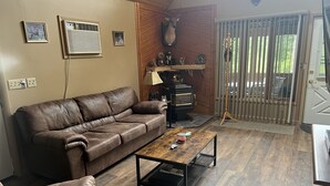 A living room with a brown leather sofa, a wooden coffee table, and a fireplace.