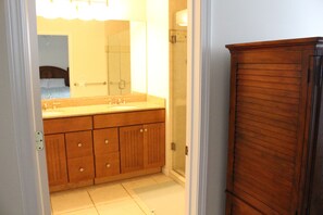 Ein Badezimmer mit Holzausstattung, einem großen Spiegel und einer Duschkabine.