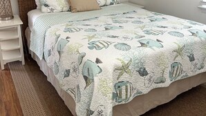 Una camera da letto con un letto, un comodino, un quadro e decorazioni murali.