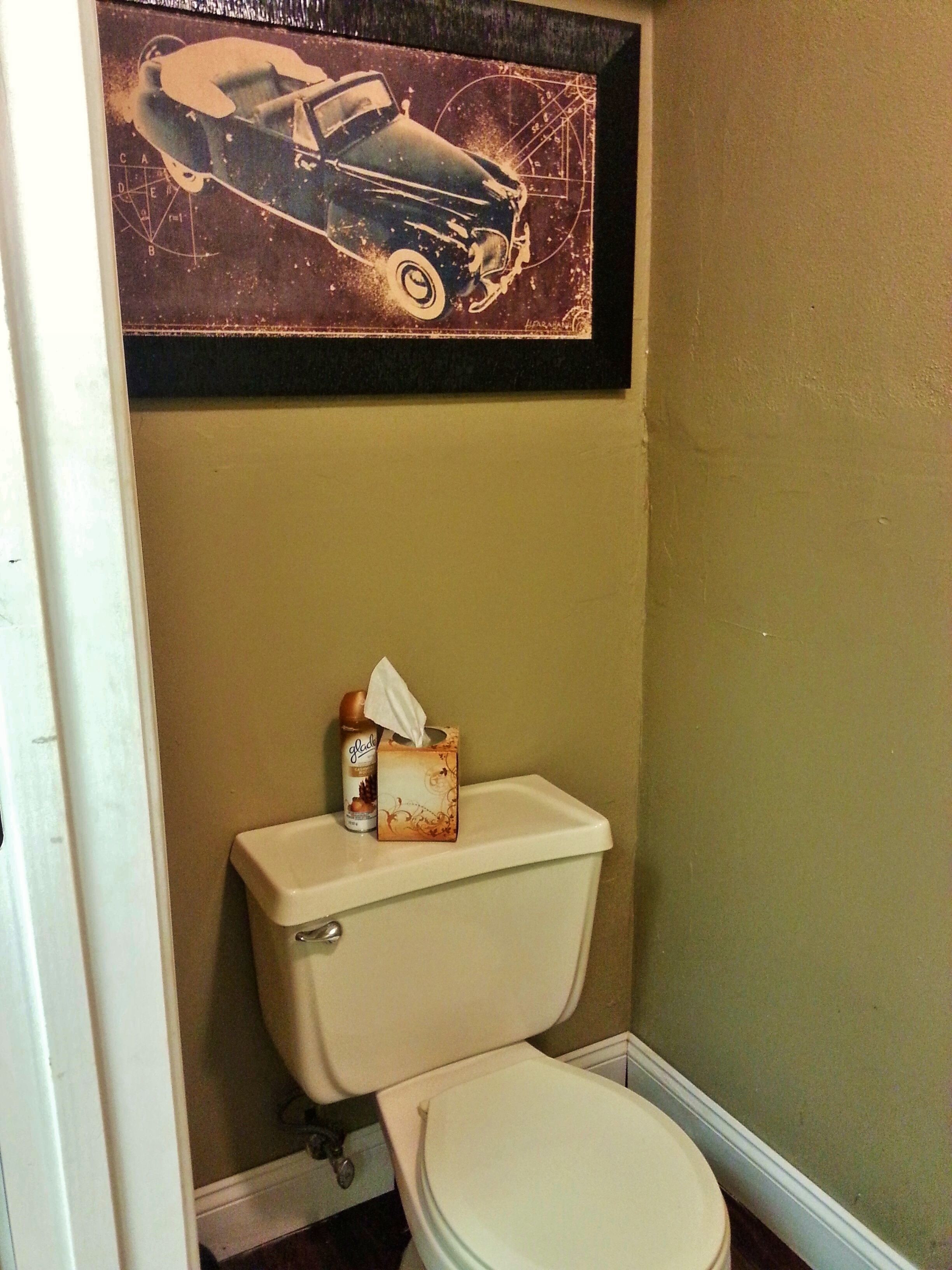 A bathroom with a toilet, a tissue box, and a bottle of hand soap.