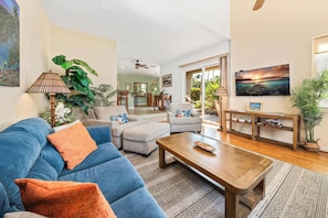 A living room with a blue sofa, a wooden coffee table, and a TV on the wall. - Includes beach gear! Waikoloa Colony Villas 1202 (Waikoloa Beach Resort)