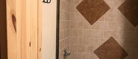 Un baño con bañera, inodoro y puerta de madera.