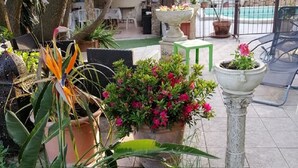 A patio area with potted plants, a stone fountain, and outdoor furniture. - Villa Lysa studio in character house private pool (La Garde)