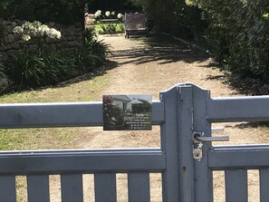 Ingresso recintato di una proprietà con un cartello che indica una località per affitti vacanze.
