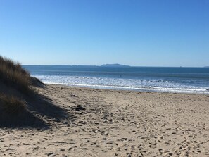 A sandy beach with gentle waves and a clear sky.