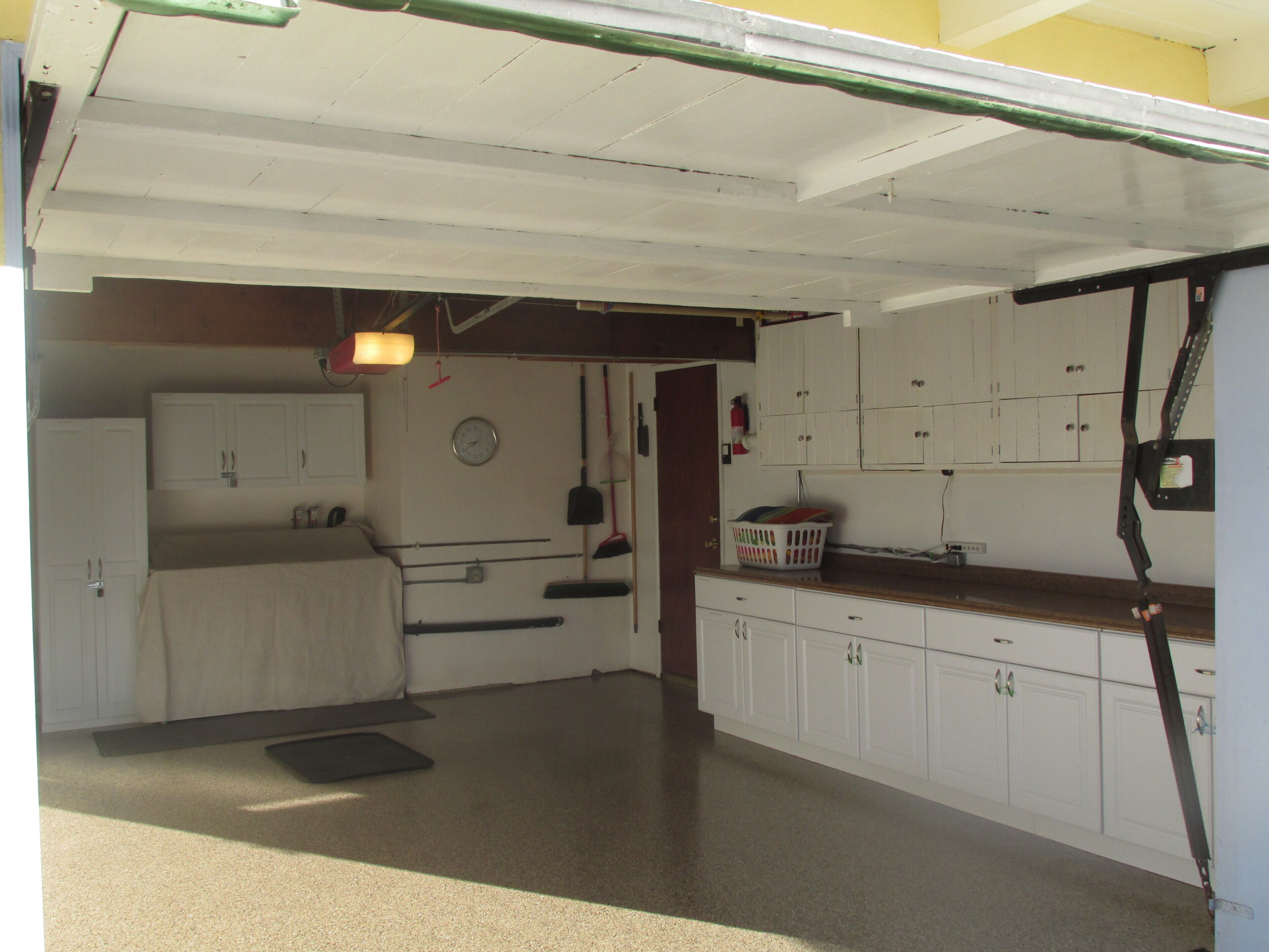 A compact kitchen with white cabinets, a sink, and a countertop.