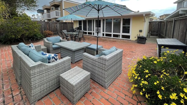 Une terrasse extérieure aménagée avec des meubles en osier, une table et un parasol.