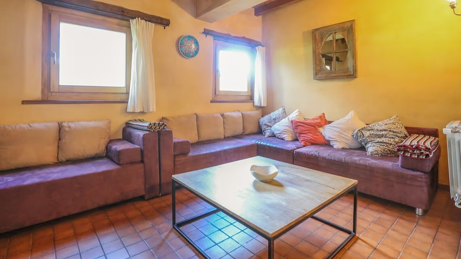 A cozy living room with a sofa set, a coffee table, and a radiator.