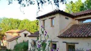 A row of traditional buildings with tiled roofs, surrounded by lush greenery and flowering plants. - Superior-Category Country Houses in a Natural Park. Nature and comfort. (Galaroza)