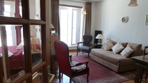 Een woonkamer met een bank, fauteuils, een salontafel en een vloerkleed.