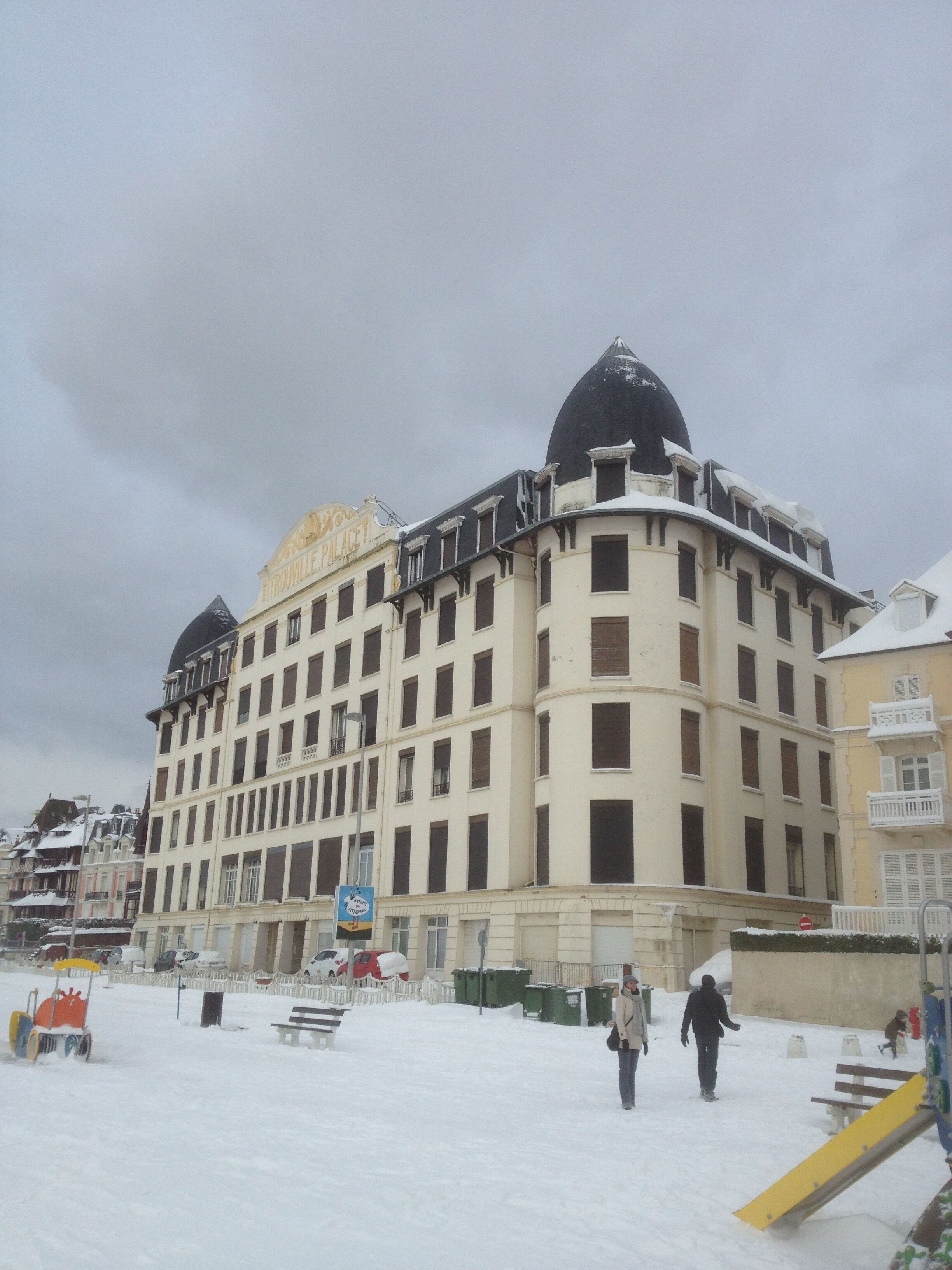 A large, multi-story building with a prominent dome and a sign that reads "Palace".