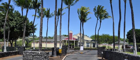 A gated entrance with a stone wall and a sign reading "Fairway Terrace."