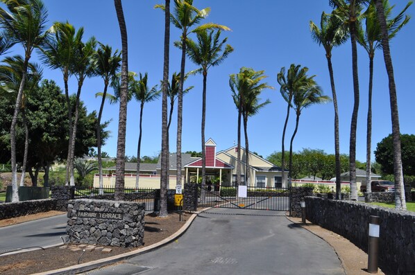 A gated entrance with a stone wall and a sign reading "Fairway Terrace."