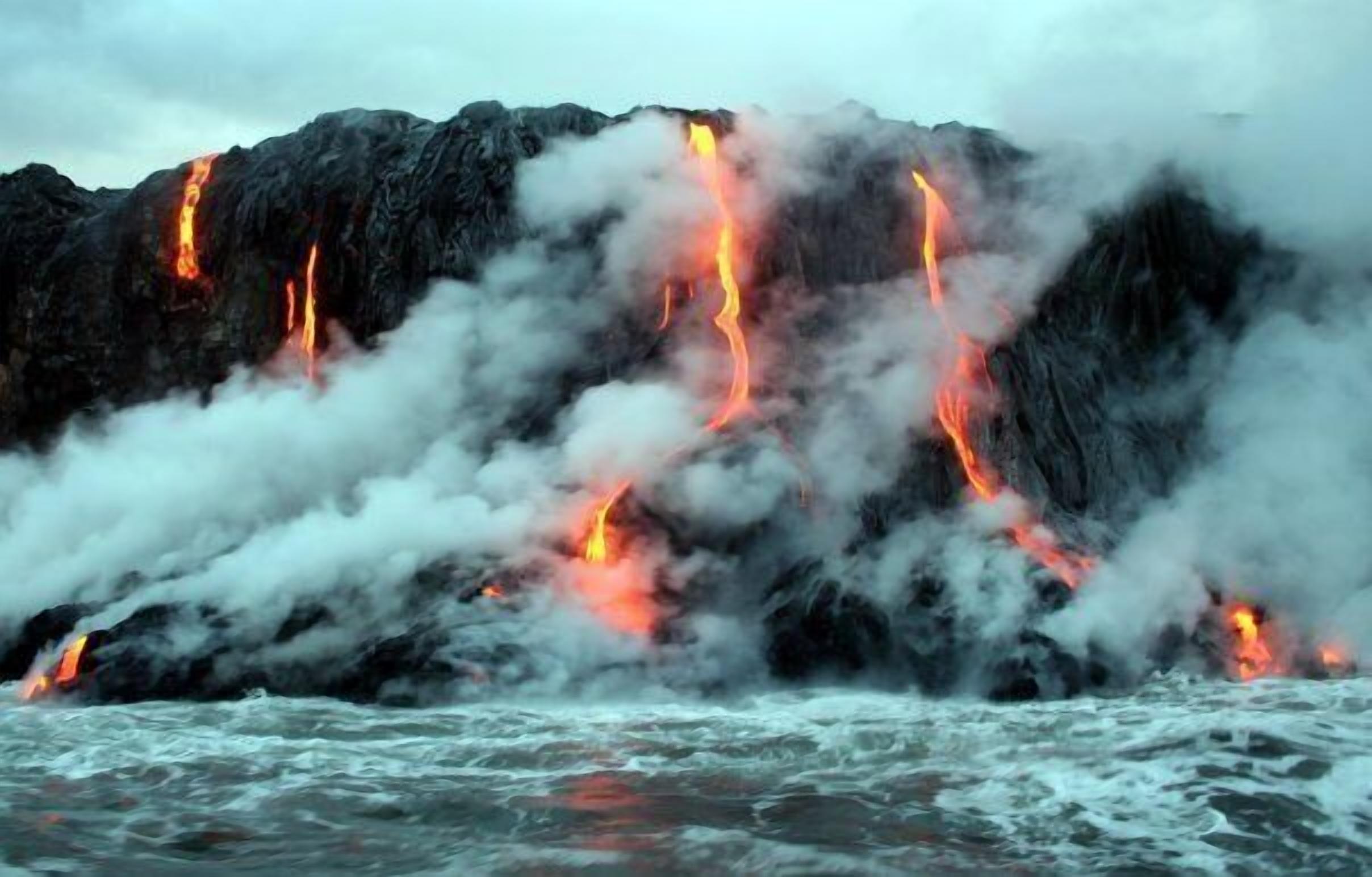 Una costa rocosa con lava fluyendo.