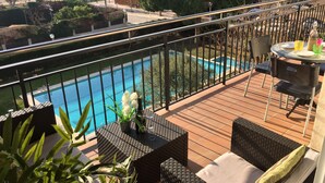 A balcony with a view of a swimming pool, outdoor furniture, and a table with drinks. - Big Apartment, Sea & Mountain views, private pool, close to amenities & IronMen  (Calella)