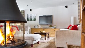 A cozy living room with a fireplace, a television, and comfortable seating.