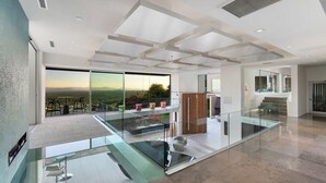 A spacious modern interior with a glass balcony overlooking a scenic landscape. - 10,000 sqf Mansion Carved into Camelback - Infinity Pool, Spa, Gym, Rooftop Bar (Phoenix)