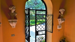 A doorway with a wrought iron gate, flanked by two bust sculptures. - ancient 1700 Villa facing Eolie Island (Milazzo)