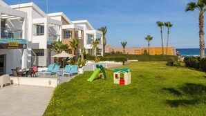 Ein modernes Hotel mit Poolbereich, Liegestühlen und einer Rutsche.