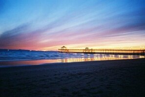 A pier extending into calm waters at sunset with a clear sky.