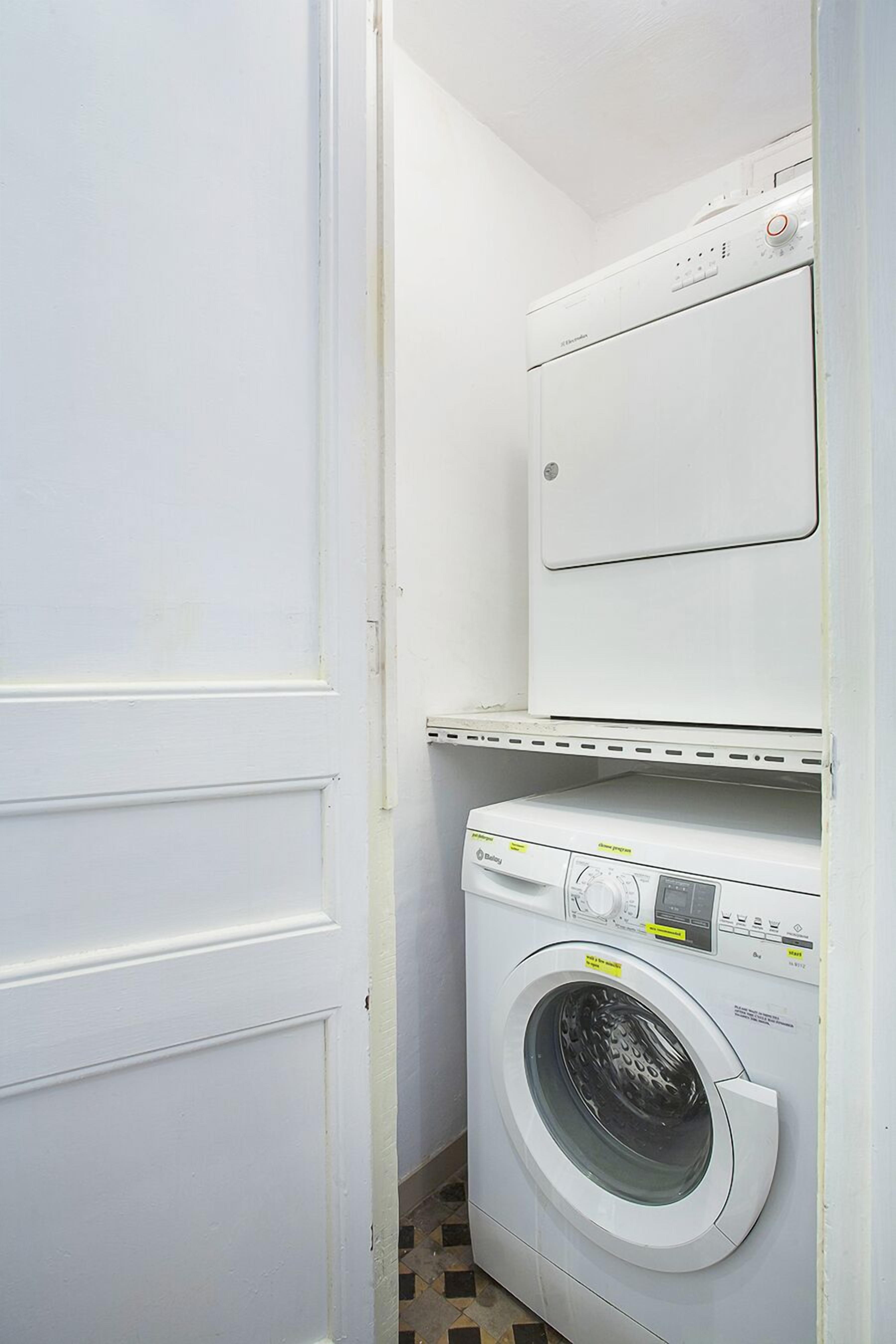 A laundry room with a front-loading washing machine and a stacked dryer.