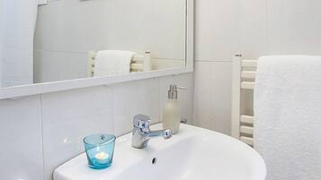 Een bad/douchecombinatie, een haardroger, een bidet, handdoeken