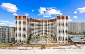 Un hôtel de grande hauteur, avec de nombreux étages, une cour intérieure et un espace piscine.