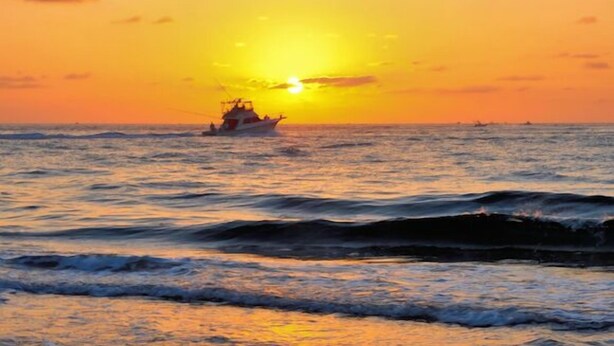 A boat on the ocean during sunset. - Cottage with Harbor and Chesapeake Bay View in Rock Hall, MD (Rock Hall)