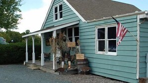 A house with a porch, a flag, and a bird feeder. - Cottage with Harbor and Chesapeake Bay View in Rock Hall, MD (Rock Hall)