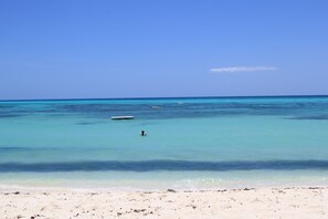 A beach with clear turquoise water and a sandy shore.
