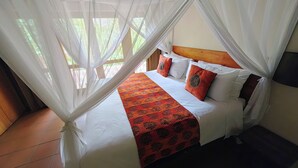 Un letto a baldacchino, biancheria da letto bianca e una coperta decorata.