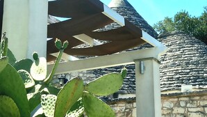 A stone wall with a pergola structure. - 'Soul of Puglia' - A Rural Gem 3BR/3BA, A/C, WiFi, Hilltop w/ POOL & Views (Ostuni / Brindisi)