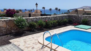 A swimming pool with stone walls and a view of the sea. - Excl. new villa with herlichen panoramic sea views over the Atlantic Ocean off Costa Calma (Costa Calma)