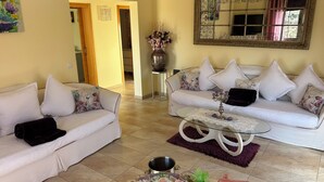 A living room with two white sofas, a glass coffee table, and a large mirror on the wall. - Excl. new villa with herlichen panoramic sea views over the Atlantic Ocean off Costa Calma (Costa Calma)