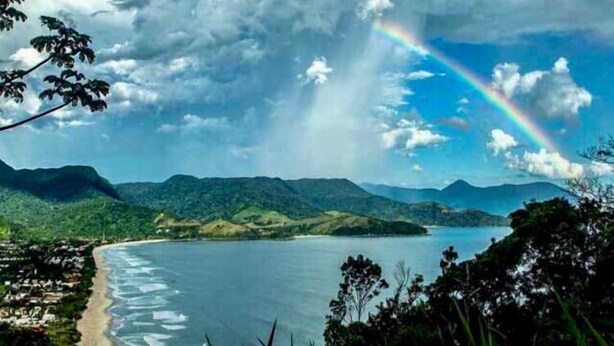 A coastal landscape with a beach, mountains, and a rainbow. - 1 BEDROOM APARTMENT, COND. CLOSED, FACING THE POOLS AND 50M FROM THE BEACH (São Sebastião)