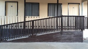 A building with a concrete staircase, wooden railings, and doors numbered 30 and 31. - Transit Motel - Hostel (Mulifanua)