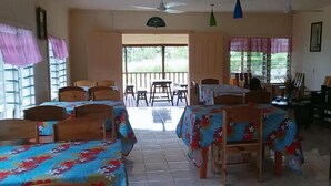 A room with multiple beds, a balcony, and a view of the outdoors. - Transit Motel - Hostel (Mulifanua)