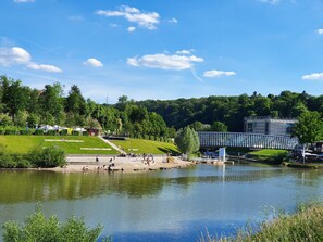 A riverside park with a pedestrian bridge, grassy areas, and a calm water body. - Feels like Home @ Eppinger, where Rems and Neckar meet (Neckargröningen)