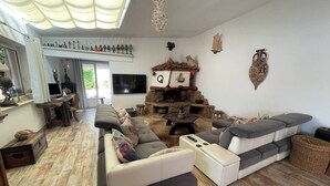 A spacious living room with a large sectional sofa, a fireplace, and a television. - L'Abri des flots Seaside Villa in Bonifacio, L'Abri des flots (Bonifacio)