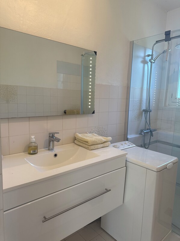 A bathroom with a sink, mirror, towel rack, and shower. - St Raphael Garden Villa very nice and quiet close to the beaches and Centre (Saint-Raphaël)