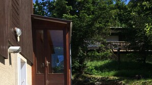 A wooden building with a large door and a set of stone steps leading up to it. - SUPER LIORAN INDIVIDUAL CHALET COMFORTABLE 8 BEDS (Laveissière)