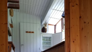 A wooden interior with a door, a small shelf with a decorative item, and a window with a view. - SUPER LIORAN INDIVIDUAL CHALET COMFORTABLE 8 BEDS (Laveissière)