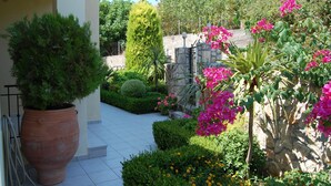 A garden with potted plants, a stone wall, and a tiled pathway. - 'Featured in Greece Magazine' Luxury Villa BREATHTAKING SEA VIEWS Kefalonia (Kourkoumelata)