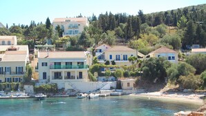 A coastal town with buildings along the waterfront, boats docked, and a clear view of the sea. - 'Featured in Greece Magazine' Luxury Villa BREATHTAKING SEA VIEWS Kefalonia (Kourkoumelata)