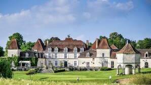 A large, historic building with multiple towers and a well-maintained lawn in front. - ACABANES Luxury Dordogne villas, 20m Bergerac airport, 5m Chateau Vigiers golf (Thénac)