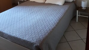 Une chambre à coucher avec un lit, des oreillers, des tables de chevet et un plafond en bois.