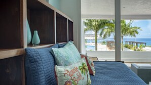 Un dormitorio con vista al océano y palmeras.