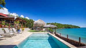 A swimming pool with lounge chairs, a thatched-roof structure, and a view of the ocean. - La Sirène du Diamant ,18 guests
Spacious beachfront rental in Martinique : (LE DIAMANT)